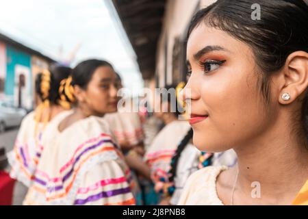 Giovane donna latina vestita in costume tradizionale del folklore nicaraguense con il suo gruppo di amici sullo sfondo a Leon Foto Stock