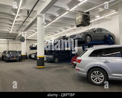 Parcheggio in garage con ascensore automatico per l'ascensore. Macchina idraulica per il sollevamento di auto da parcheggiare in pile doppie. - New York, Stati Uniti d'America - 2022 Foto Stock