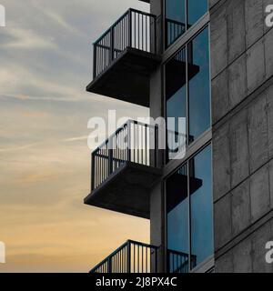 Nuvole Puffy quadrato sul lato del tramonto di un alto edificio con ringhiere sui balconi a Salt L. Foto Stock