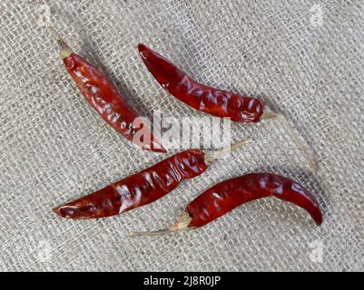 Spezie, peperoncino su sfondo di lino grigio chiaro testurizzato, vista dall'alto ravvicinata Foto Stock