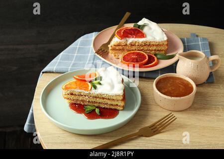 Composizione di delizioso dessert con torta meringa con agrumi su tavola di legno Foto Stock