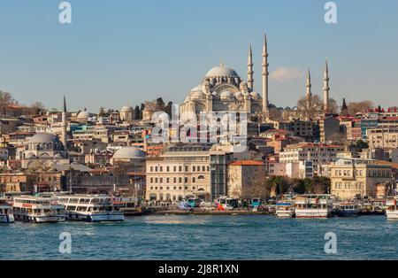 Istanbul, Turchia, 22 marzo 2019: Vista al molo di Eminonu e alla moschea di Suleymaniye attraverso la baia del Corno d'Oro in mattinata di sole. Navi turistiche i Foto Stock