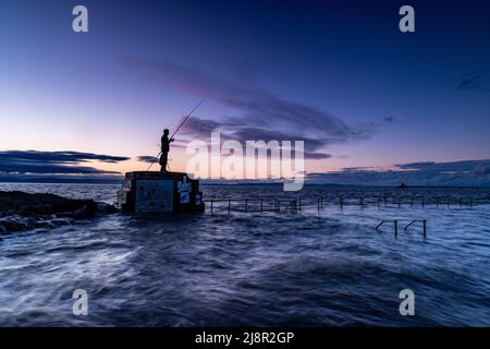 Clevedon Marine Lake, Regno Unito. 17th maggio 2022. Un pescatori al lago marino come la marea crescente trabocca il muro di mare durante l'alta marea in Somerset credito: steven paston/Alamy Live News Foto Stock