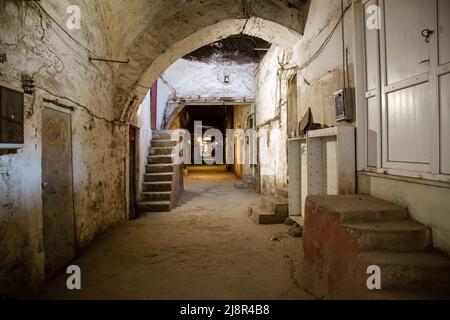 Il vecchio tunnel abbandonati nella baraccopoli cantina sotterranea. Ingresso alle catacombe urbano. Il lato inferiore del cavalcavia della città vecchia di calcestruzzo usurato la riparazione industriali sporchi Foto Stock