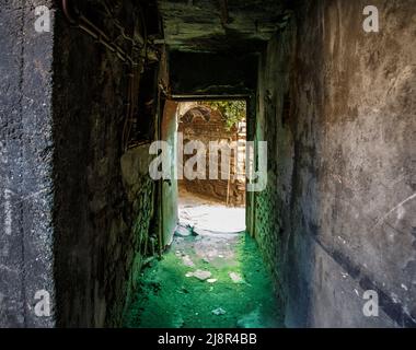 Il vecchio tunnel abbandonati nella baraccopoli cantina sotterranea. Ingresso alle catacombe urbano. Il lato inferiore del cavalcavia della città vecchia di calcestruzzo usurato la riparazione industriali sporchi Foto Stock