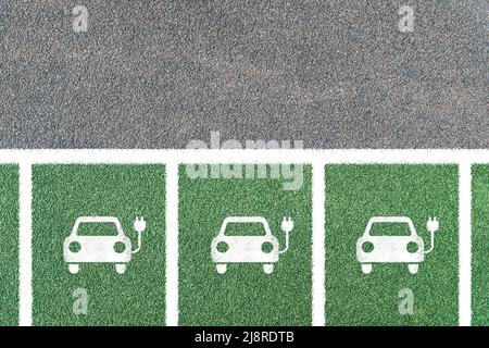 Parcheggio per auto elettriche solo con simboli. Stazione di carica del veicolo elettrico con l'icona della spina elettrica. Spazio di copia. Foto Stock