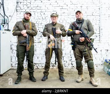 Tre membri della forza di difesa territoriale del quartiere di Kotsiubynske visti con i loro fucili a Kyiv. Foto Stock