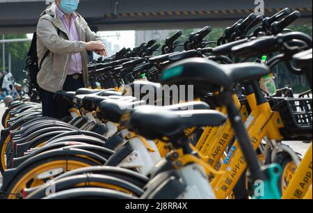 Pechino, Cina. 18th maggio 2022. Un uomo ha le sue mani igienizzate prima di andare in bicicletta condivisa fuori da una stazione della metropolitana a Pechino, capitale della Cina, 18 maggio 2022. A Pechino, le biciclette condivise sono state disinfettate e alcune di esse sono dotate di igienizzanti manuali recentemente come misure di precauzione COVID-19, per la salute dei piloti in occasione della recente rinascita COVID-19. Credit: Chen Zhonghao/Xinhua/Alamy Live News Foto Stock