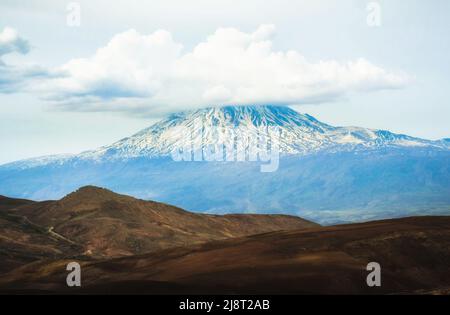 Paesaggio di montagna innevata ararat picco con nuvola passare dal lato della Turchia in primavera. Ai piedi del mt Ararat Foto Stock