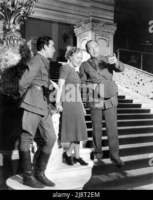 ANTHONY QUINN e LIONEL ATWILL in set Candid with Female Set Visitor / Fan durante le riprese dell'ULTIMO TRENO DA MADRID 1937 regista JAMES P. HOGAN Paramount Pictures Foto Stock