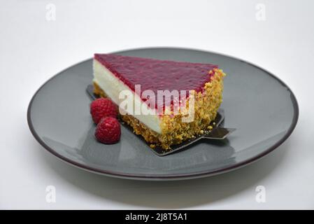 Pezzo di cheesecake con lamponi isolato su sfondo bianco. Foto Stock