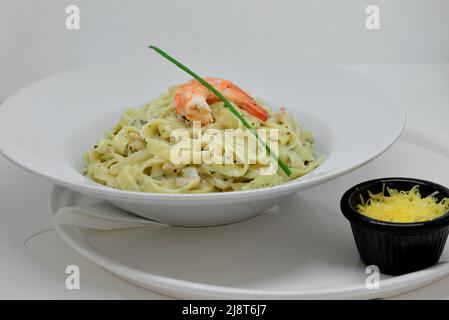 Pasta italiana fettuccine con gamberi in salsa cremosa con parmigiano e timo in un piatto Foto Stock