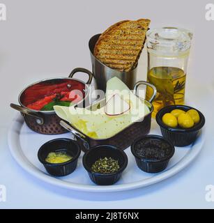 La prima colazione comprende pane tostato, formaggio, olio e olive Foto Stock