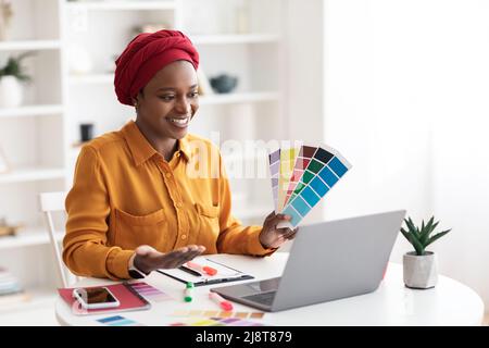 Allegra designer musulmana afroamericana che ha una videoconferenza Foto Stock