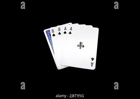 Due coppie di eights e assi con una carta rovesciata. Mano di poker 'Dead Mans Hand' isolata su sfondo nero Foto Stock