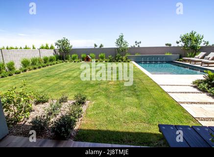 Vista della Yard posteriore casa con Dog House e piscina Foto Stock