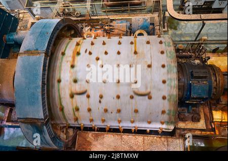 Enorme mulino a sfere di macinazione funziona con minerale in pianta Foto Stock