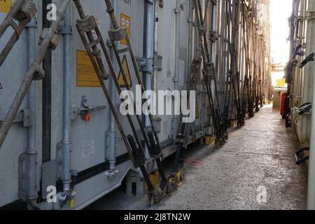 Fila di contenitori di diversi caricatori fissati sul ponte principale della nave. Foto Stock