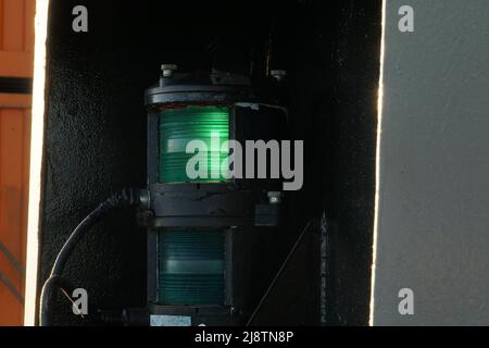 Vista ravvicinata sulle luci di navigazione verdi a dritta della nave portacontainer. Foto Stock