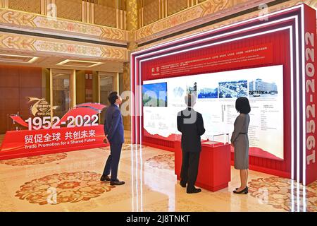 Pechino, Cina. 18th maggio 2022. La gente guarda una mostra prima dell'apertura della conferenza del 70th anniversario del Consiglio cinese per la promozione del commercio internazionale (CCPIT) e del Vertice globale per il commercio e la promozione degli investimenti a Pechino, capitale della Cina, 18 maggio 2022. Credit: Li Xin/Xinhua/Alamy Live News Foto Stock