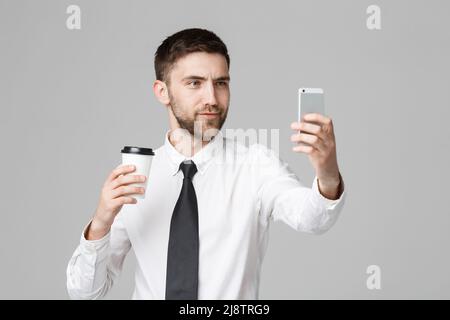Lifestyle and Business Concept - Ritratto di un bel uomo d'affari godere di prendere un selfie con take away tazza di caffè. Sfondo bianco isolato Foto Stock
