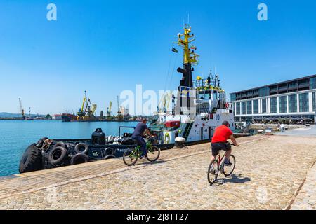 Burgas, Bulgaria - 17.05.2022: Il rimorchiatore si trova al molo nel porto marittimo in una giornata estiva soleggiata. Cielo blu chiaro senza nuvole e mare calmo. Porta c Foto Stock