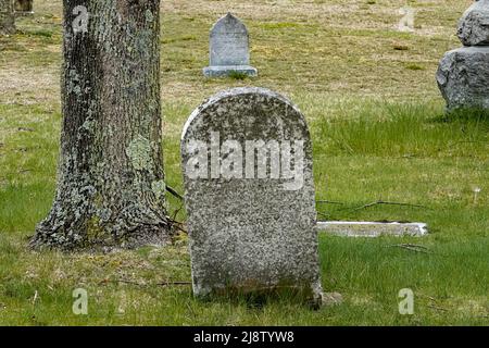 Un vecchio cimitero sembra inquietante anche alla luce del giorno, con la sua collezione di pietre di testa intemperie Foto Stock