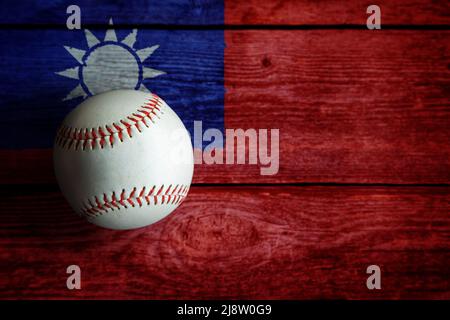 Baseball in pelle su sfondo rustico in legno dipinto con bandiera taiwanese con spazio copia. Taiwan o Taipei cinese è una delle nazioni di baseball più importanti Foto Stock