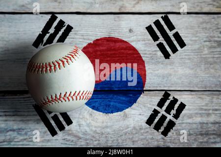 Baseball in pelle su sfondo rustico in legno dipinto con bandiera sudcoreana con spazio per la copia. La Corea del Sud è una delle nazioni di baseball più importanti del mondo Foto Stock