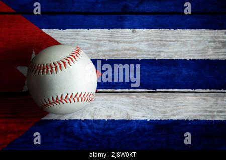 Baseball in pelle su sfondo rustico in legno dipinto con bandiera cubana con spazio copia. Cuba è una delle nazioni di baseball più importanti del mondo. Foto Stock