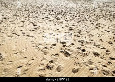 Un sacco di impronte su una spiaggia di sabbia Foto Stock