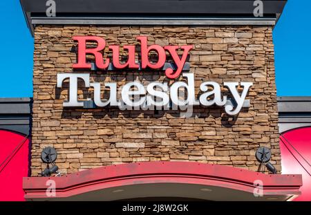 Esterno 'Ruby Tuesday' facciata marchio e logo per esterni in grassetto rosso e bianco lettere su sfondo di pietra in una luminosa giornata di sole. Foto Stock