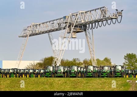 Mannheim, Germania - Aprile 2022: File di nuovi trattori agricoli parcheggiati in un deposito nella periferia di Mannheim Foto Stock