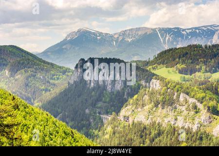 Semmering: Vista dalla torre di prospettiva Doppelreiterwarte a Semmeringbahn (Semmering Railway) e il Polleroswand, treno locale, sullo sfondo il Rax Foto Stock