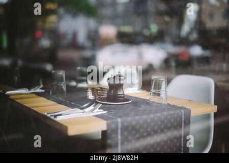 Piatto sul tavolo di legno nel ristorante interno attraverso la finestra Foto Stock