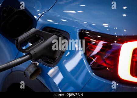 Energia di carico di un'auto elettrica blu. Alimentazione di carica all'auto elettrica EV, primo piano. Foto Stock
