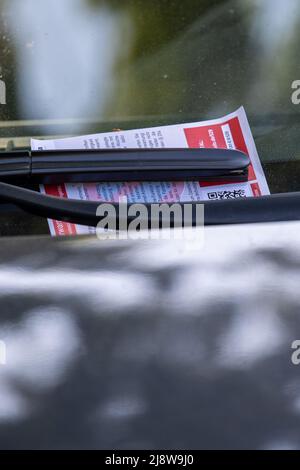 Pirna, Germania. 18th maggio 2022. Un'auto è parcheggiata in una zona di parcheggio con un biglietto per il parcheggio sul tergicristallo. Il conducente della macchina aveva dimenticato di inserire un disco di parcheggio, così il dipartimento di polizia della città di Pirna ha emesso un avvertimento. Credit: Daniel Schäfer/dpa/Alamy Live News Foto Stock