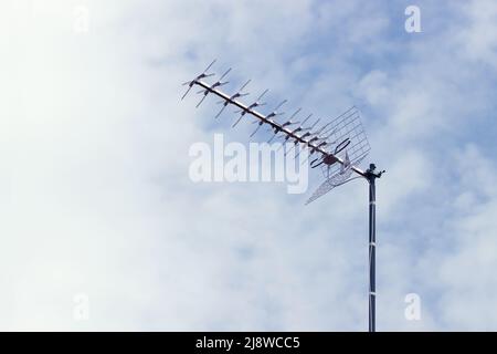 Immagine di un'antenna televisiva di tipo Yagi per la ricezione della televisione digitale terrestre (DTT) su un cielo limpido con nuvole e spazio di riproduzione Foto Stock