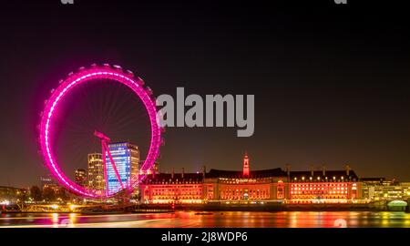 Il London Eye di notte, illuminato da luce rosa, si trova lungo la Queen's Walk. Londra. Foto Stock