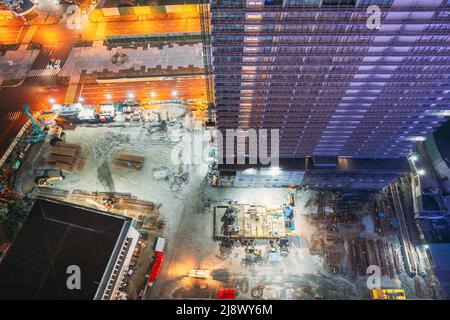 Sviluppo di edifici residenziali a più piani nelle ore notturne. Sviluppo in cantiere. Lavori notturni. vista piana costruzione e costruzione di edifici Foto Stock