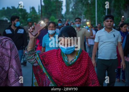 Srinagar, India. 17th maggio 2022. I Kashmiri Indù, localmente conosciuti come 'pandit', tengono delle torce mobili durante la protesta a Budgam contro l'uccisione di Rahul Bhat un dipendente del governo che è stato ucciso da sospettati ribelli all'interno del suo ufficio a Chadoora Budgam. Mentre le autorità indiane hanno assicurato alla comunità Kashmiri Pandit che tutti i lavori e le questioni relative alla sicurezza saranno risolti tra una settimana, la comunità richiede il trasferimento dalla regione del Kashmir il più presto possibile, dicendo che non possono rischiare la loro vita per lavoro. Credit: SOPA Images Limited/Alamy Live News Foto Stock