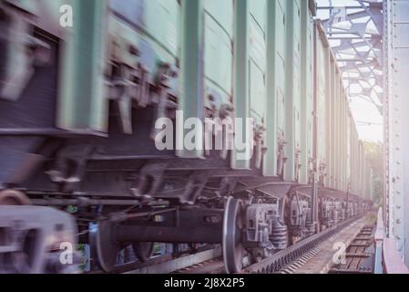 Trasporto merci lungo il treno si avvicina alla stazione al tramonto. Foto Stock