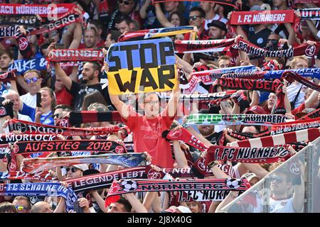 Norimberga, Germania. 15th maggio 2022. Tifosi, tifosi di calcio Norimberga e Schalke, amicizia dei tifosi, sciarpe. Un ventilatore tiene in su un segno ARRESTO GUERRA (guerra in Ucraina) Calcio 2nd Bundesliga stagione 2021/2022, 34.matchday, matchday34. 1.FC Norimberga - FC Schalke 04 1-2, il 15th maggio 2022, MAX MORLOCK STADIUM. Credit: dpa/Alamy Live News Foto Stock