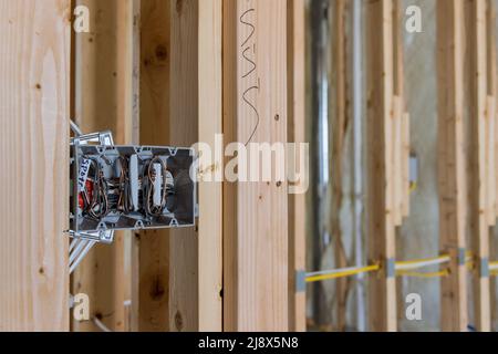 Gli elettricisti instradano i fili nelle prese elettriche del connettore a spina sulla parete Foto Stock