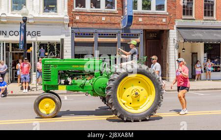 Travis e il figlio giovane di Gina Vaughn che guidano un vecchio trattore John Deere Foto Stock