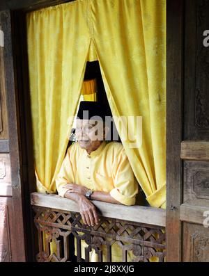 Un uomo malese che indossa un cappello tradizionale. Foto Stock