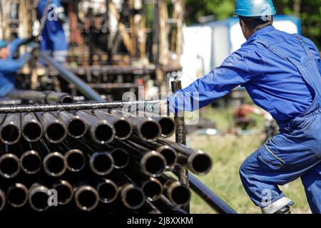 L'operatore dell'industria petrolifera e del gas utilizza tubi di perforazione per carro di perforazione su un carro di perforazione per pozzi petroliferi. Foto Stock