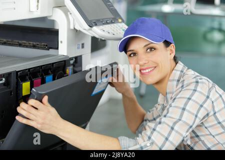 donna sta riparando una stampante Foto Stock