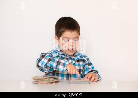 Un ragazzo di 4 anni gioca con carte con immagini, materiale didattico per bambini in età prescolare. Foto Stock