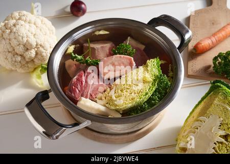Ossa fresche di midollo, carne di manzo e verdure in una pentola d'acqua - preparazione di brodo fatto in casa Foto Stock